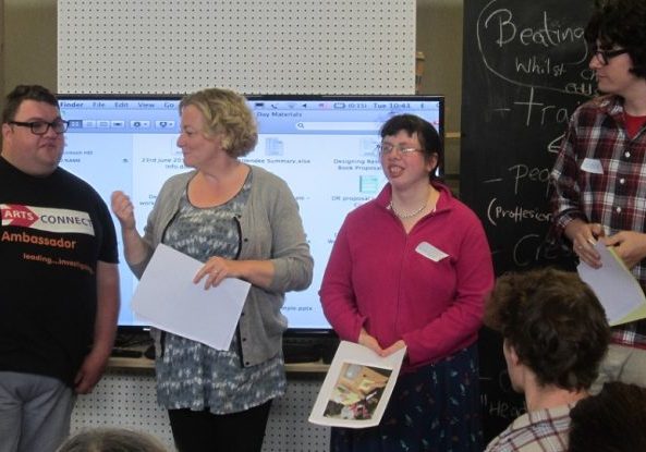 Four people standing in front of a screen giving a presentation of PhD research